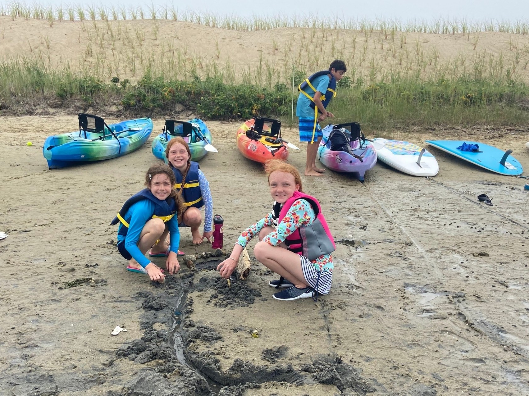 Children playing in the sand after kayaking to their destination beach during Kids Camp with RideAway Adventures