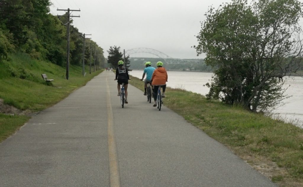 canal-shot-behind-1024×632 a person riding a bike down a dirt road