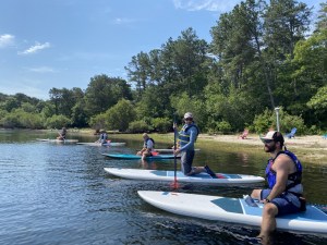 a group of people riding on the back of a boat in the water