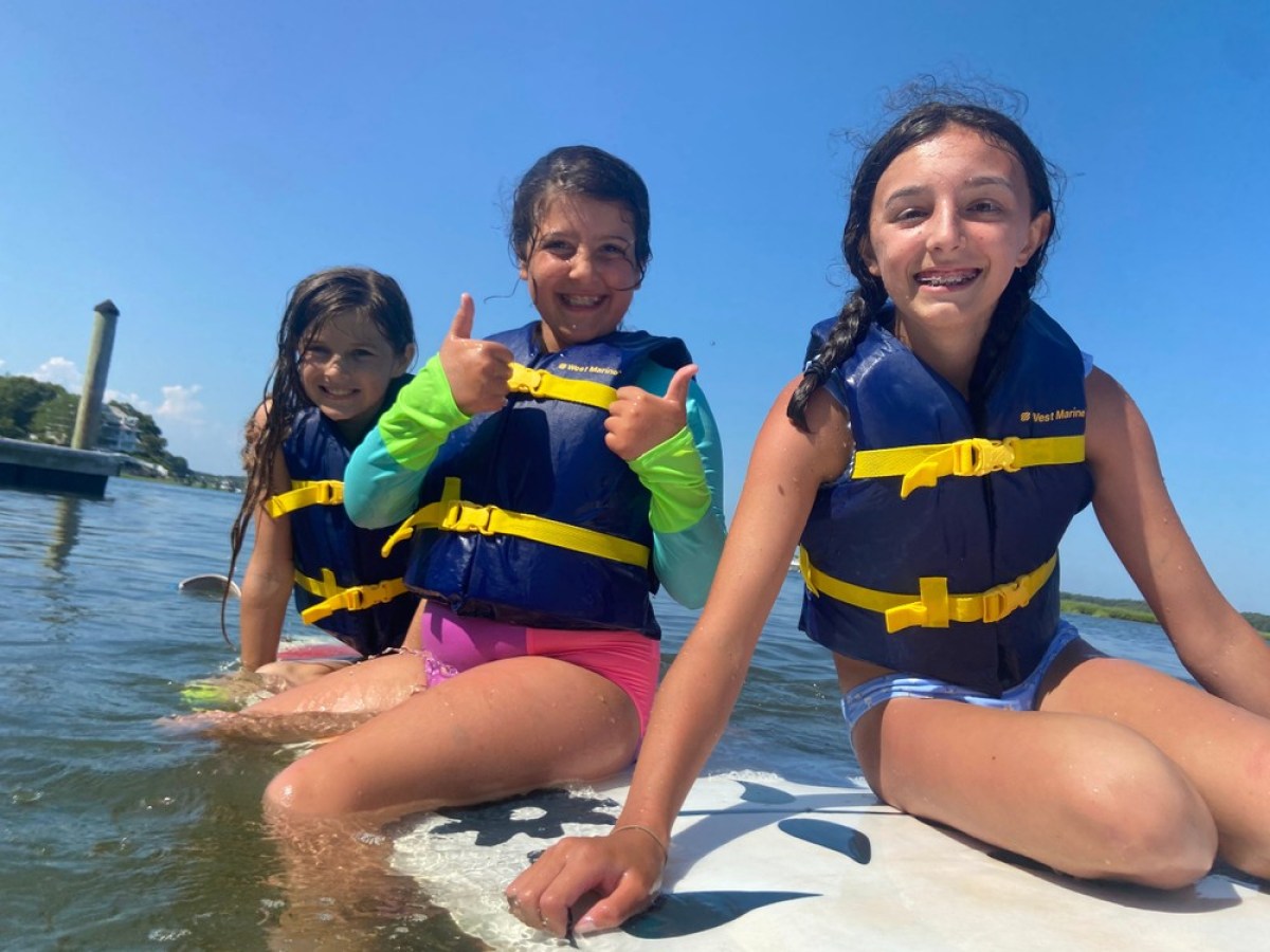 Three kids giving a thumbs on a stand up paddleboard rental from RideAway Adventures