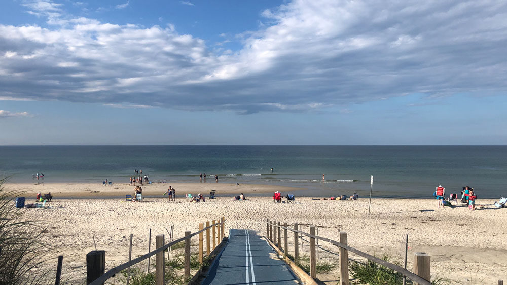 a group of people on a sandy beach next to the ocean