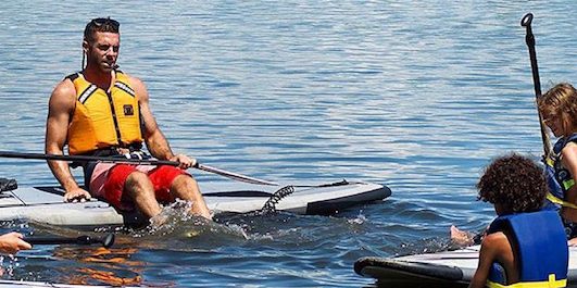 a group of people rowing a boat in the water