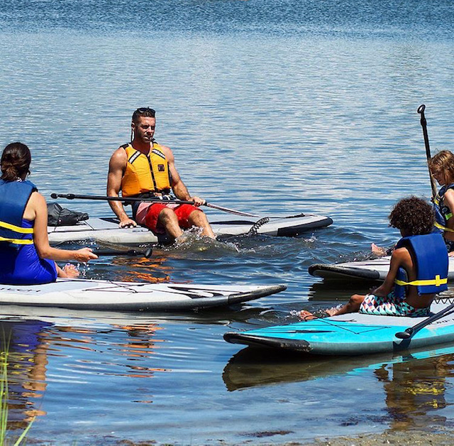 a group of people rowing a boat in the water